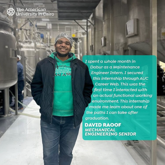 A male is smiling and standing in a factory, he is wearing a plastic cover on his head. Text reads: David Raouf, Mechanical Engineering Senior